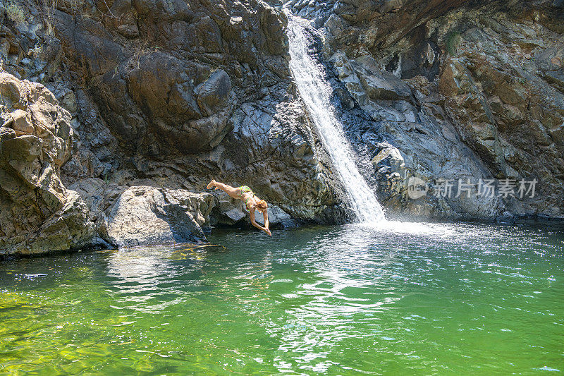 年轻女子在瀑布中游泳。土耳其穆格拉Koycegiz的极地瀑布。