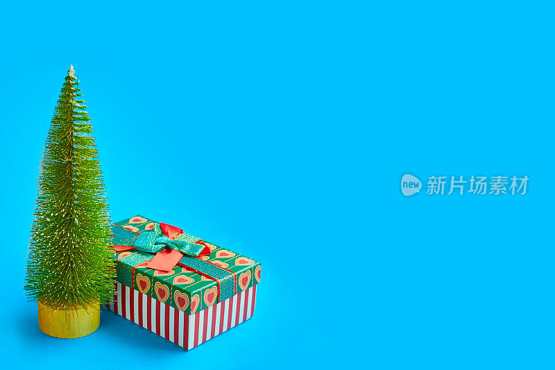 圣诞树和礼盒上的蓝色背景，抽象的背景，极简的新年概念。