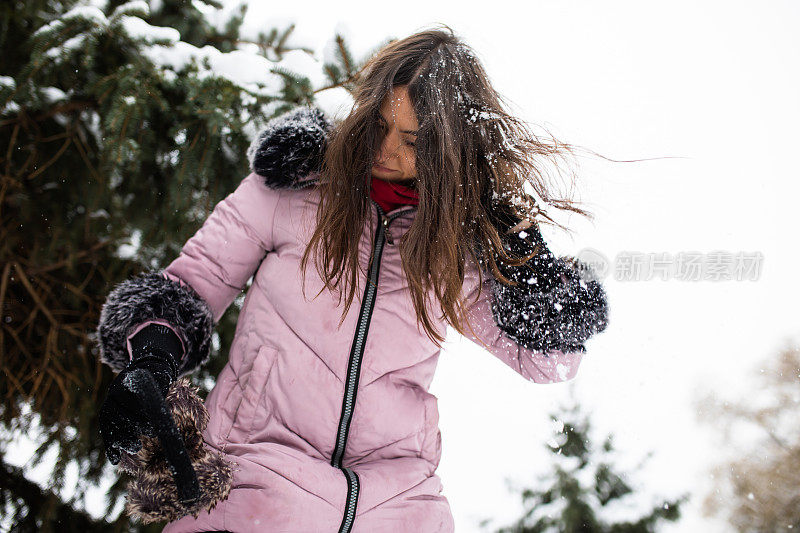 一个女人正在把头发上的雪弄掉