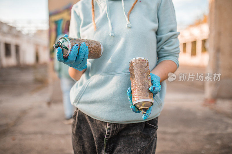 一位才华横溢的女艺术家手持涂鸦喷雾器的特写镜头