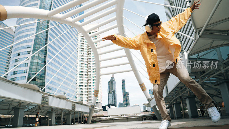 时尚快乐的亚洲男子表演嘻哈舞与低角度相机。活泼的。