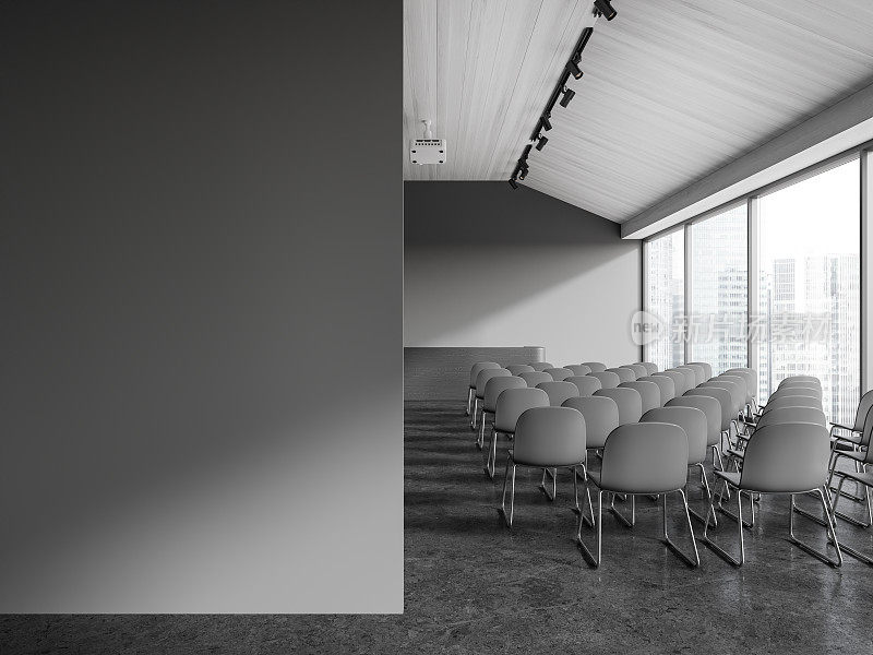 灰色的演讲厅内部有椅子和空白的墙壁