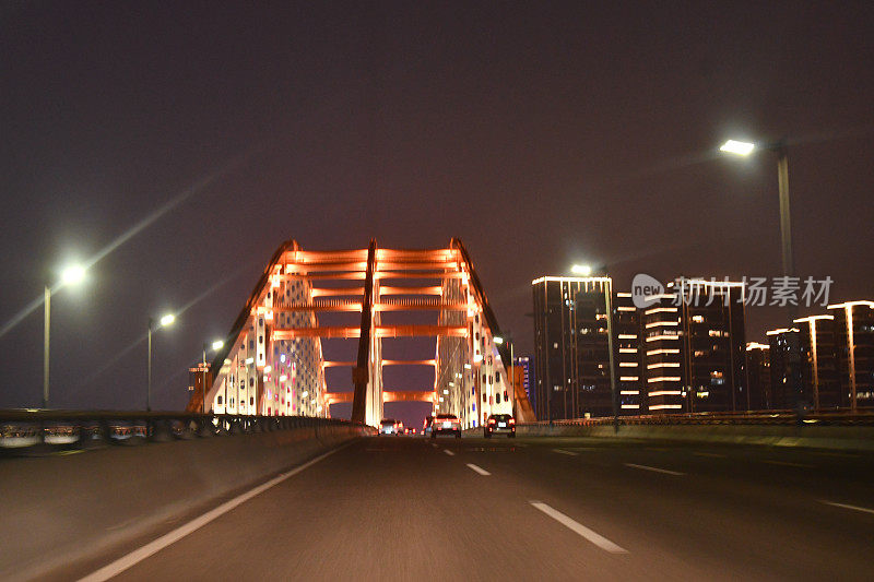 夜间高速公路上快速驶向大桥