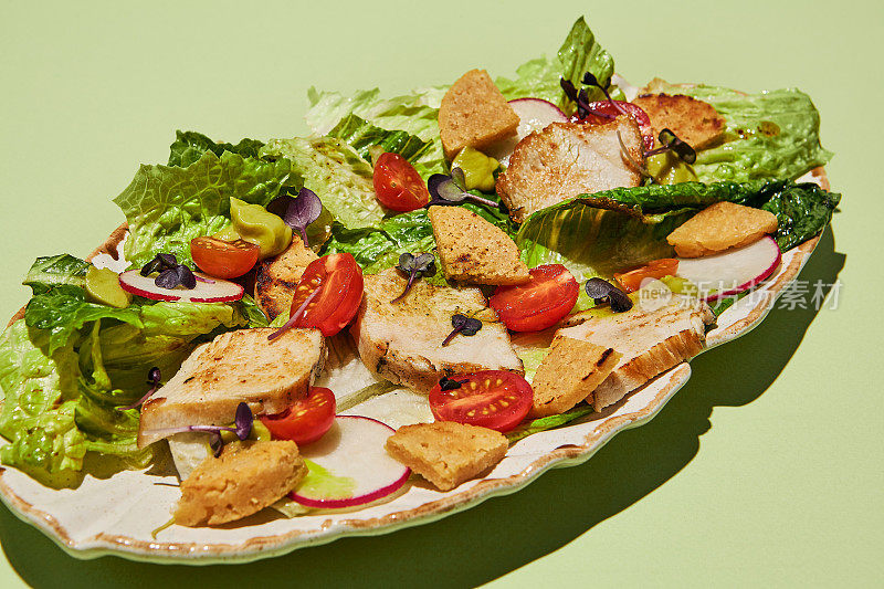 一个健康的凯撒或火鸡沙拉的特写镜头，配上酥脆的蔬菜和脆脆的面包丁，突出了质地和新鲜度