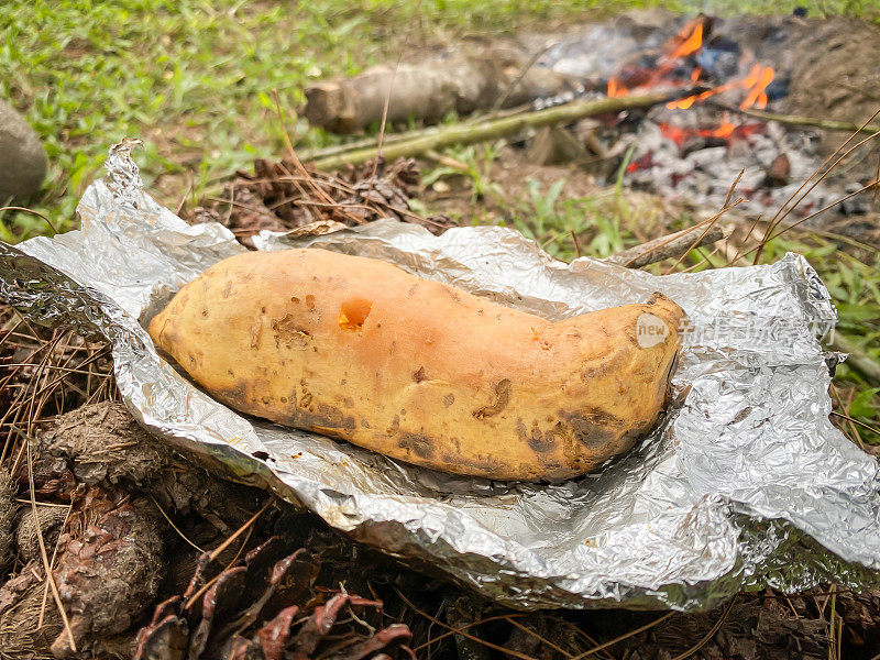 无论何时Cilembu。周末露营户外活动时，一堆刚烤好的红薯放在铝箔上。健康饮食的概念，复合碳水化合物，饮食，替代食品安全。