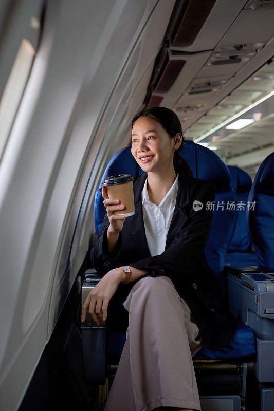 一名年轻的亚洲女子坐在商务舱的窗户附近。旅游和商务理念。