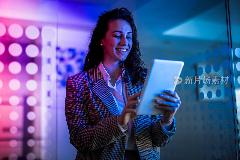 年轻的女企业家用平板电脑在虚拟办公室工作。女人触摸虚拟屏幕。戴着VR眼镜在办公室工作的女人。