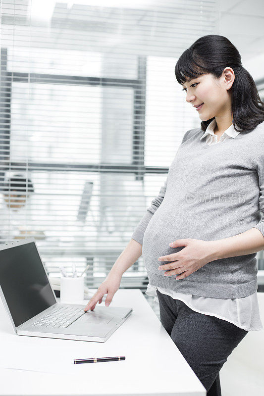 怀孕的商务女士使用笔记本电脑