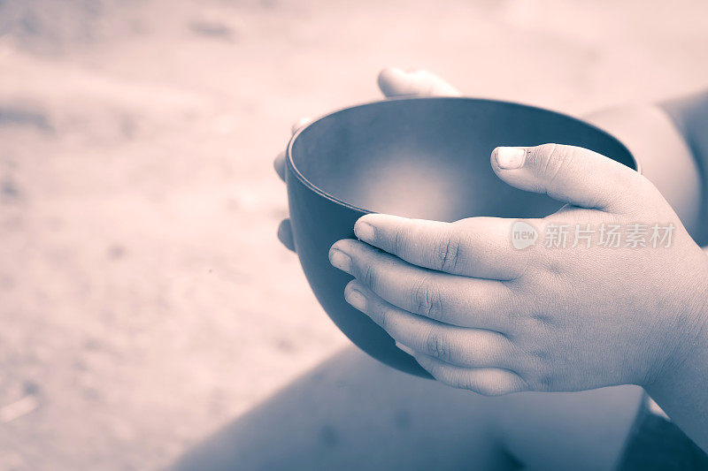 复古的颜色一个饥饿的孩子拿着一个空碗