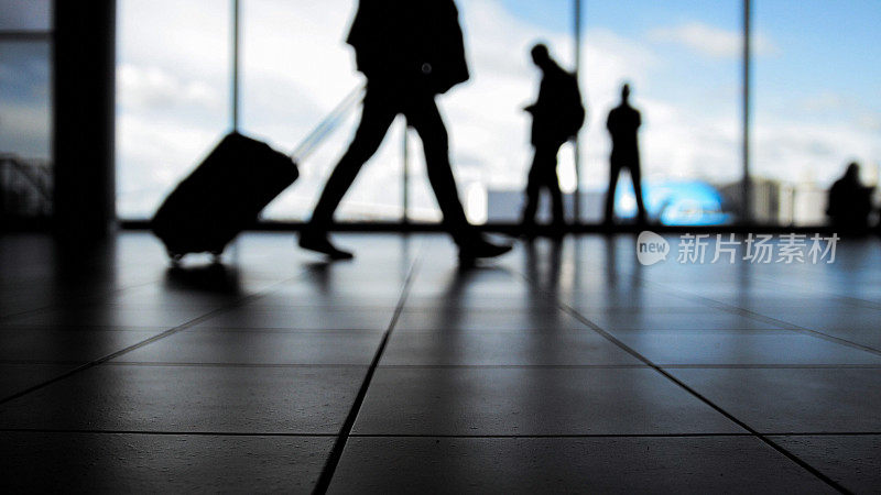旅客在机场搭乘前面的自动扶梯前往离境