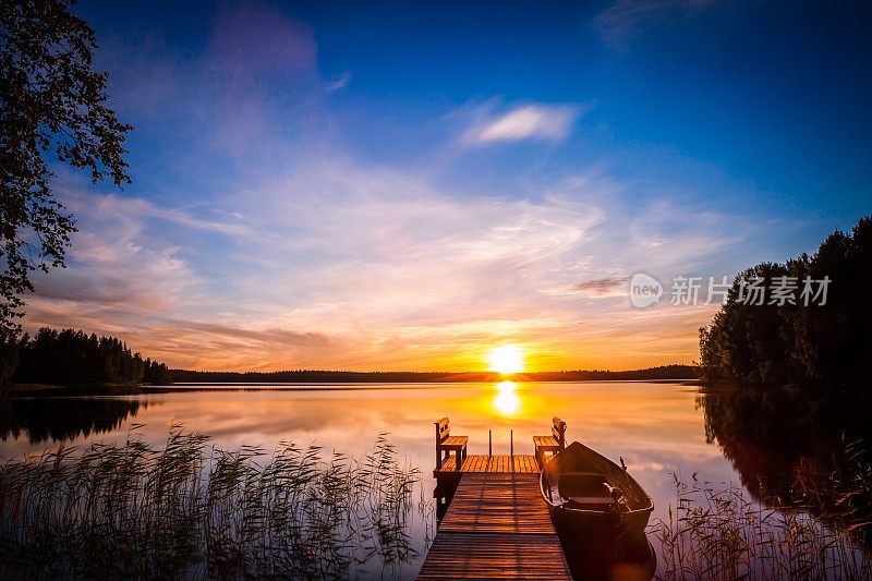 日出在芬兰湖边的钓鱼码头上