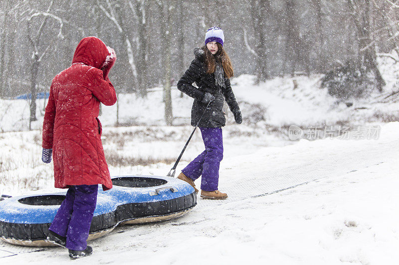 Snowtubing。两个女孩要去山顶