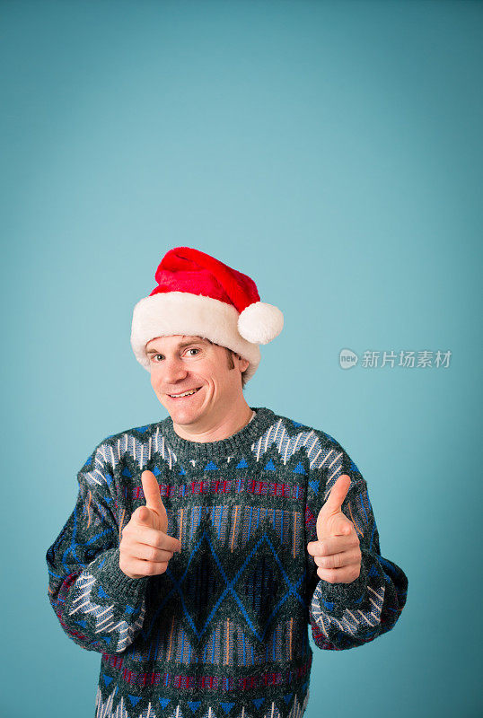 男人，戴着圣诞帽，穿着丑陋的毛衣，还竖起大拇指