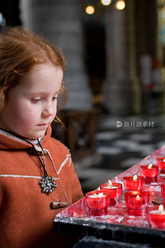 小女孩在教堂里拿着蜡烛