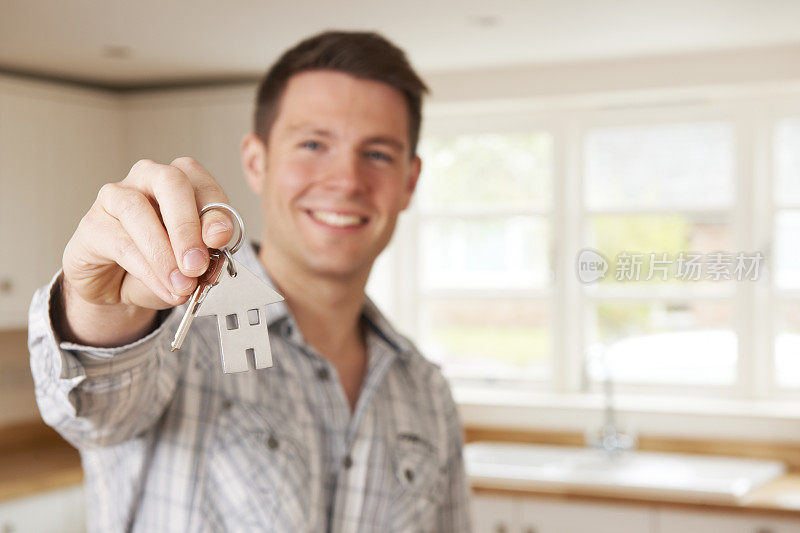 男人搬进新家持有房子形状的钥匙圈