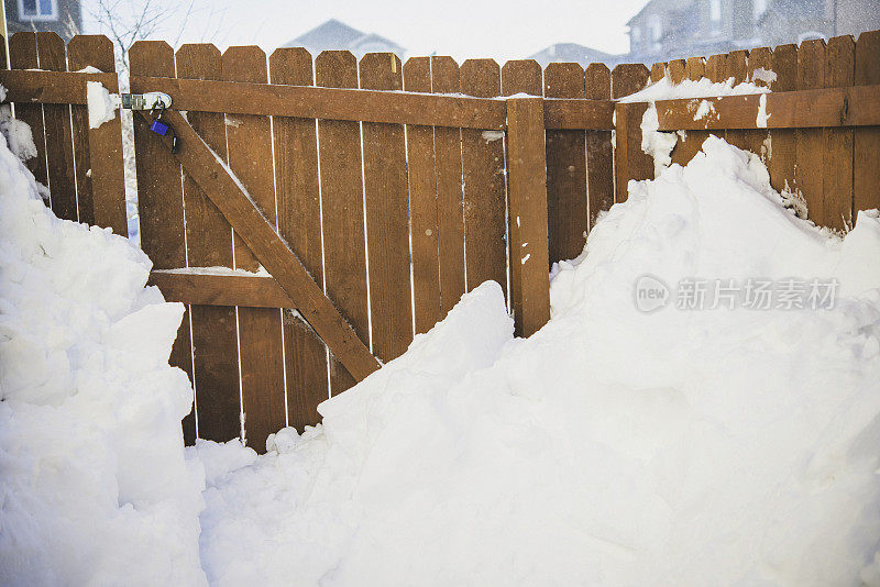 暴风雪过后，雪靠着花园篱笆堆得很高。美国科罗拉多州