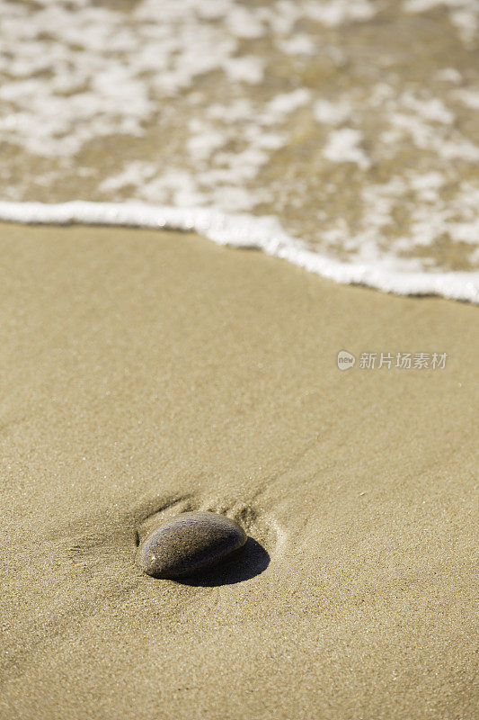 海浪轻轻地拍打着沙滩上的卵石