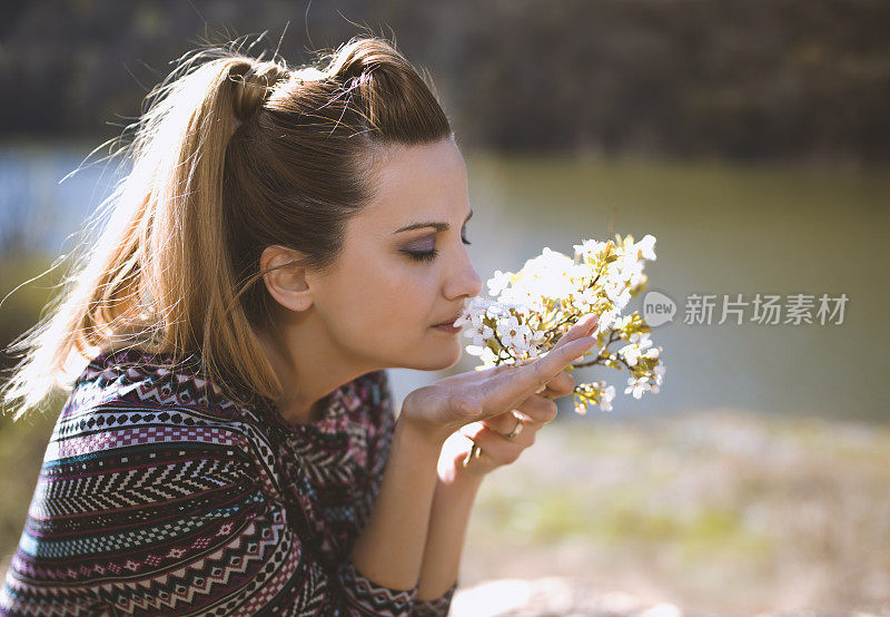 女人带着春天的花在山上的湖