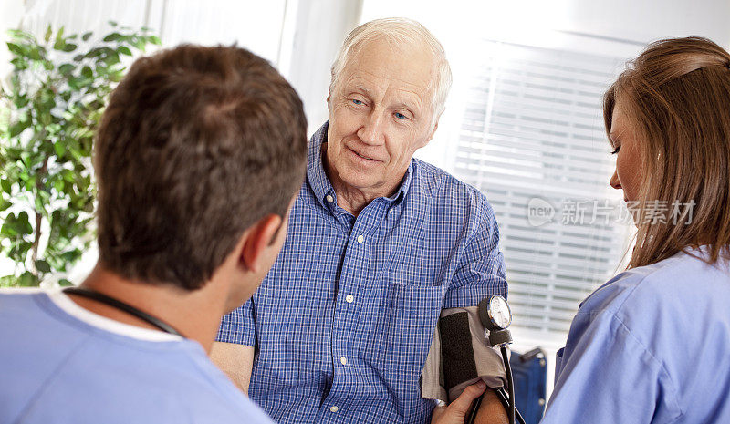 老人正在接受医生检查，护士在检查血压