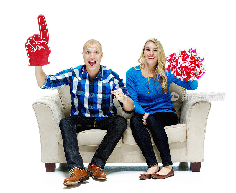 一对快乐的夫妇坐在沙发上，手指上涂着泡沫