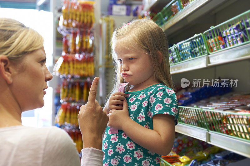 孩子在糖果柜台和妈妈吵架