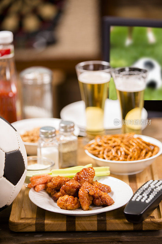 在当地酒吧看电视足球赛。鸡翅膀。