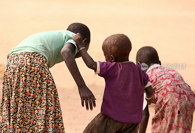 三个非洲孩子在沙漠里互相帮助
