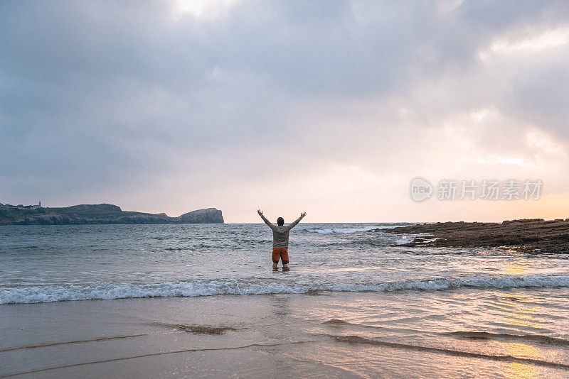 一个年轻人正在海滩上洗澡