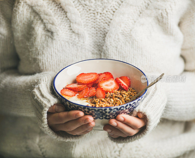 健康早餐酸奶，格兰诺拉麦片，草莓碗女人手里