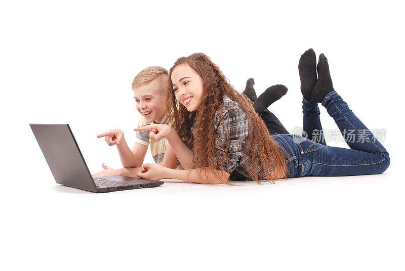 男孩和女孩躺在地板上用笔记本电脑