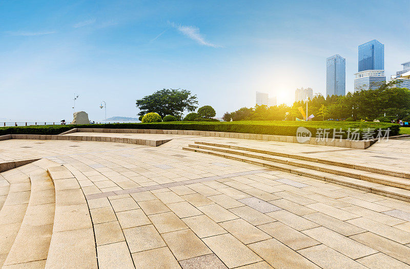 在中国青岛，全景天际线和建筑物与空的混凝土广场地板