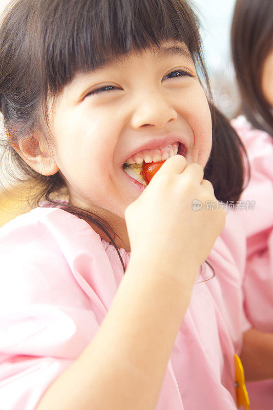 幼儿园的女孩吃樱桃番茄