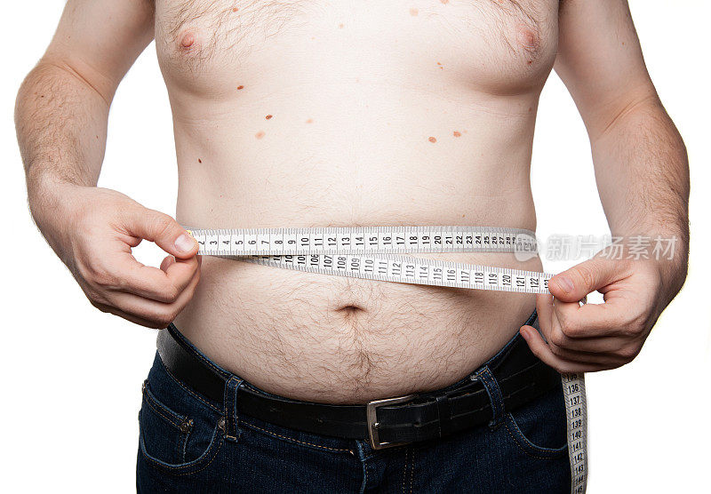 一个有腹部脂肪的男人测量他的腹部