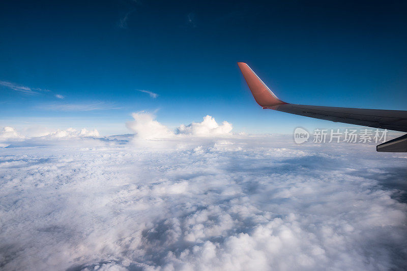 飞机机翼对着多云的天空