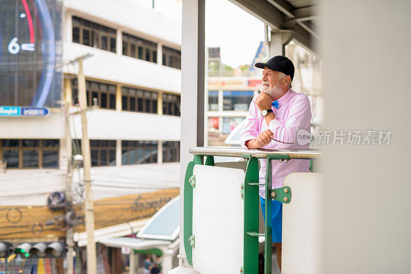 在泰国曼谷BTS空中火车站，一位穿着时髦衣服的帅老头的画像