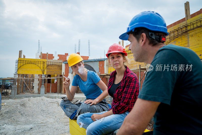 三个建筑工人在建筑工地休息