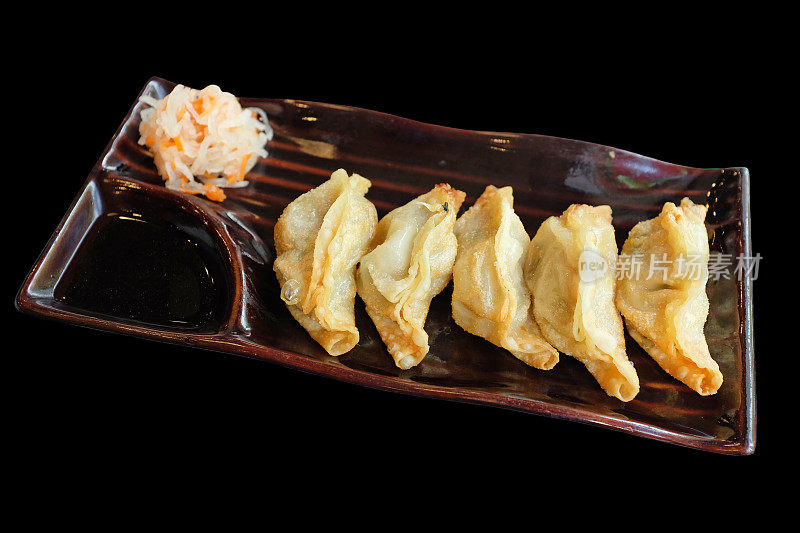 煎饺孤立在黑色背景上。受欢迎的日本食品。