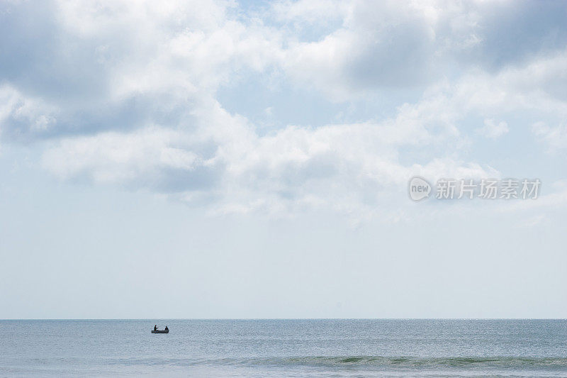 平静海面上的小渔船剪影