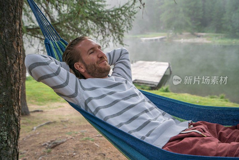 在瑞士山景中的吊床上放松的快乐的人