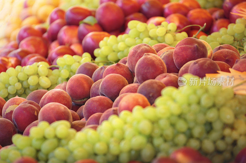 市场摊位上的新鲜水果(葡萄、桃子、油桃)