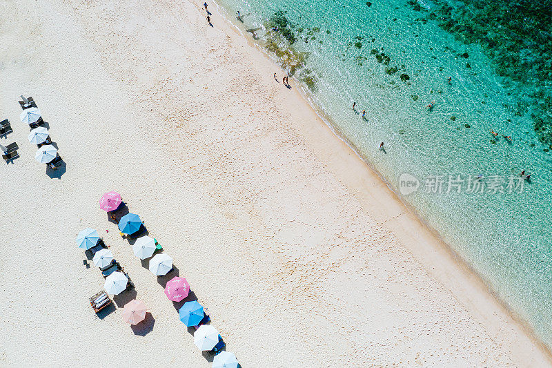 海滩伞和蓝色的海洋。从上面看海滩景色