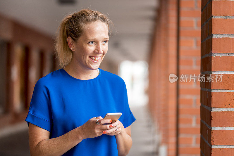 年轻女子在户外拿着手机