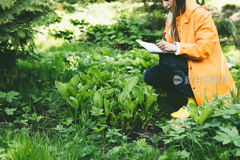 女人在花园里做关于种植的笔记