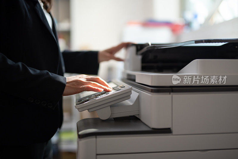 在办公室用复印机复印的女商人