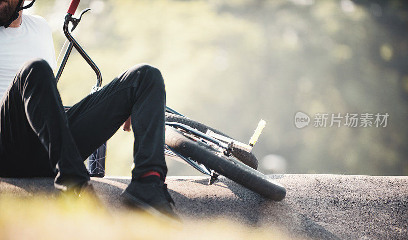 年轻的小轮车自行车骑手在骑行后休息