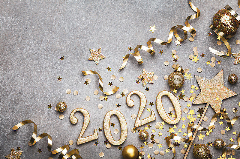 假日背景与金色圣诞装饰和2020年数字和五彩缤纷的星星俯视图。