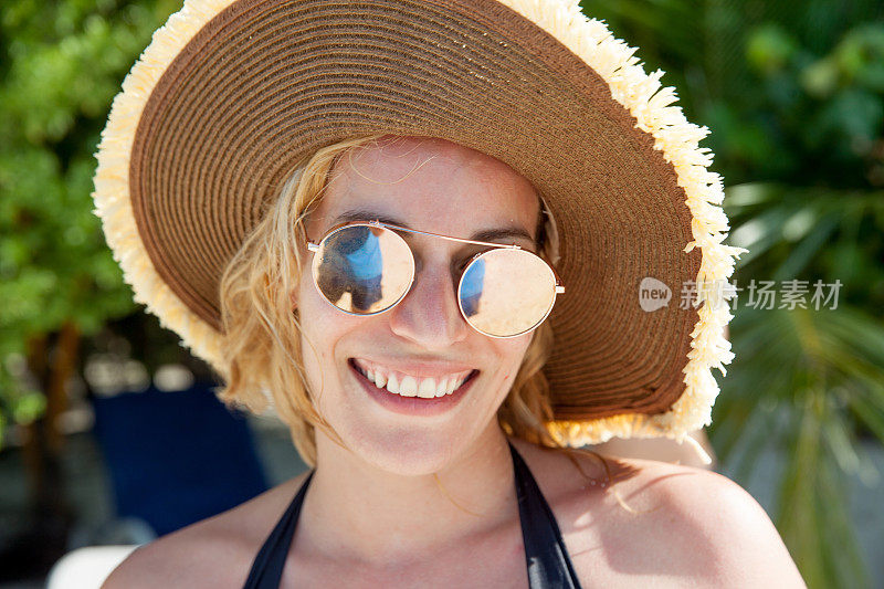 年轻女子肖像与草帽在热带海滩