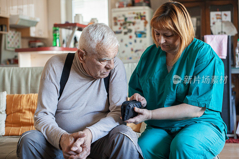 护士帮助一位老人检查血糖。