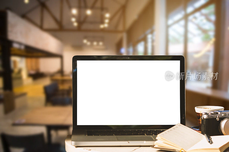 在咖啡店的背景木桌上的笔记本电脑的黑白屏幕与相机，笔记本电脑，咖啡杯的模型图像。