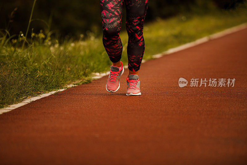 在跑道上慢跑的不知名的女运动员